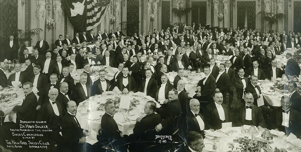 Hans Sulzer (in der Mitte des Längstisches unter den Fahnen) im New York Swiss Club am Dinner zu seinen Ehren im Hotel Astor, 6. Oktober 1917.